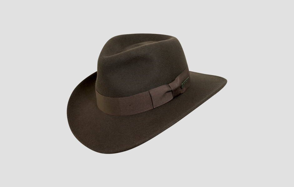 A brown Indiana Jones hat with gold pin