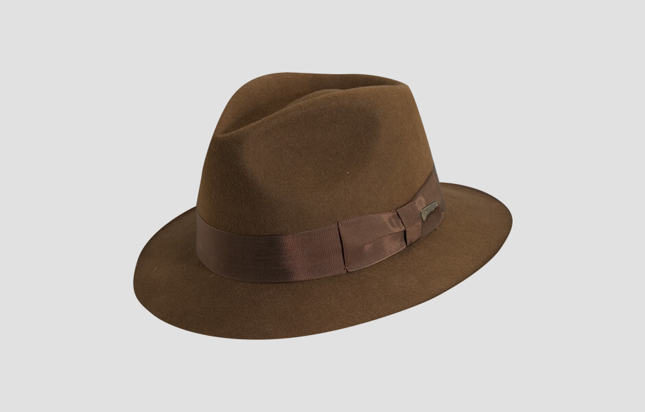 A light brown Indiana Jones hat with gold pin