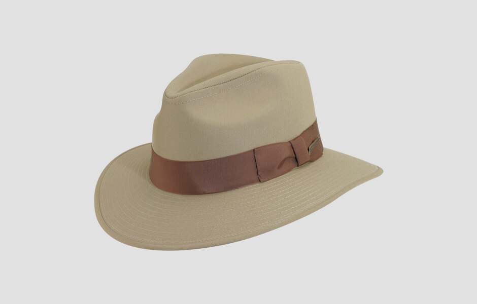 A tan Indiana Jones hat with a brown band and gold pin